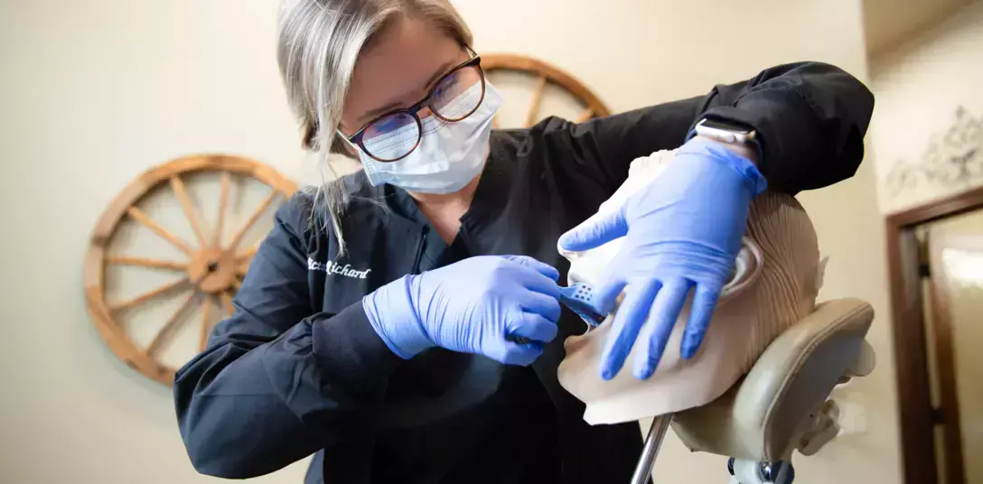 {{ school.name }} instructor demonstrating a dental examination