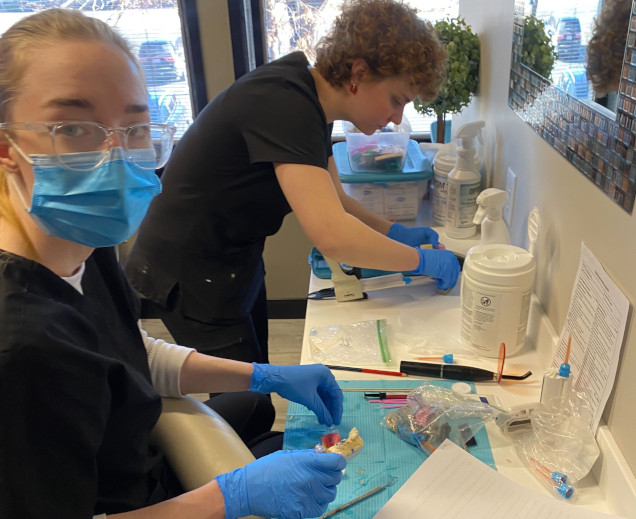 {{ school.name }} students creating dental molds in the lab