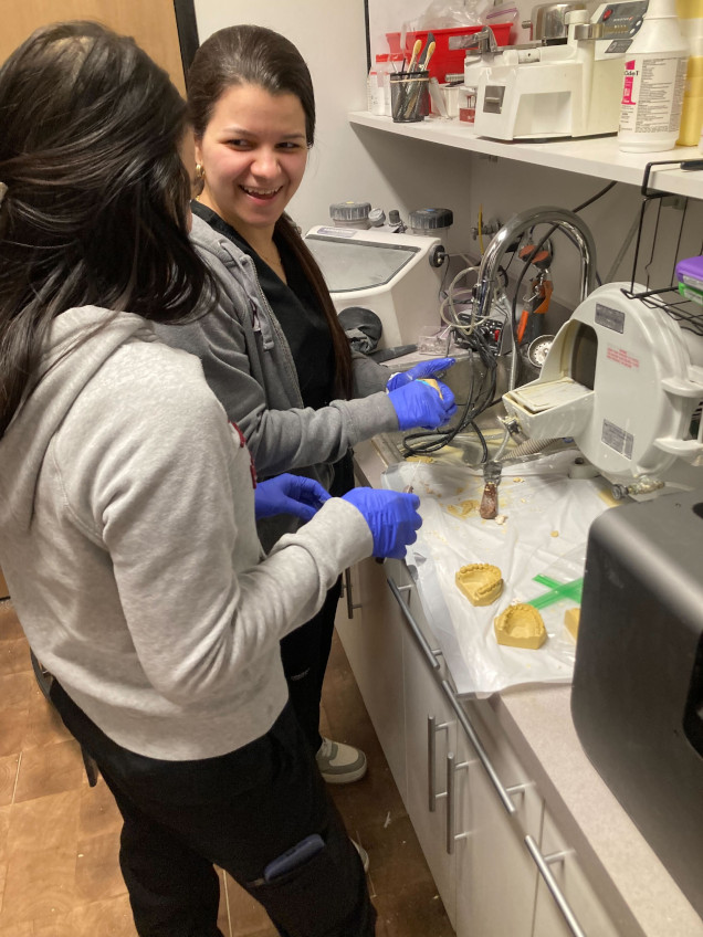 {{ school.name }} students training to create dental molds in the lab