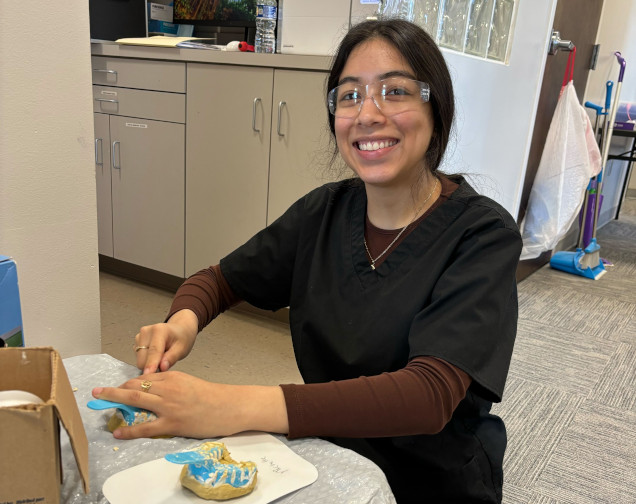 {{ school.name }} student creating a dental mold in class